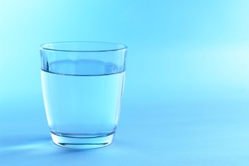 Glass of water in blue