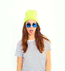 Portrait of young stylish girl model in casual summer clothes in yellow beanie hat isolated on white. Showing her tongue