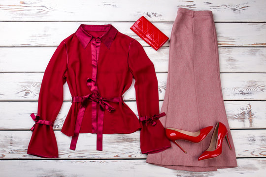 Red women clothes set. Silk robe, dress, wallet and pair of high heel shoes, flat lay.