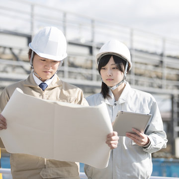 工事現場で図面を見る作業員
