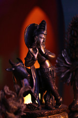 Figurine in Buddhist style. The musician plays on the pipe