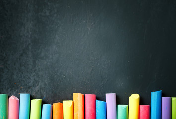 Colorful crayons on the blackboard, drawing. Back to school background.