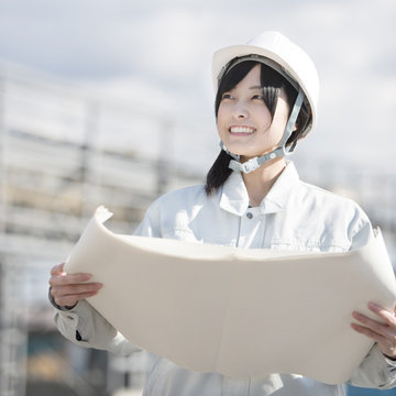 図面を持ち微笑む作業員