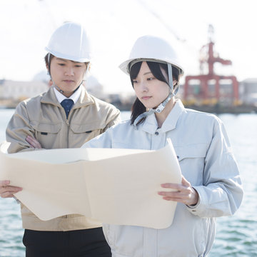 工事現場で図面を見る作業員