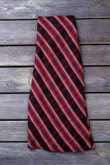 Black and red checkered long skirt. Flat lay, top view. Grey wooden surface background.