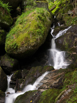 Waterfall, cascade between big rocks in ravine Ysperklamm