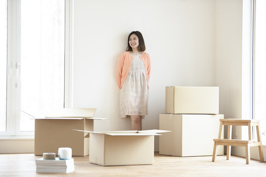 壁に寄りかかり微笑む女性