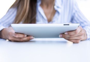 close up of young business woman using a tablet computer sitting on terrace.