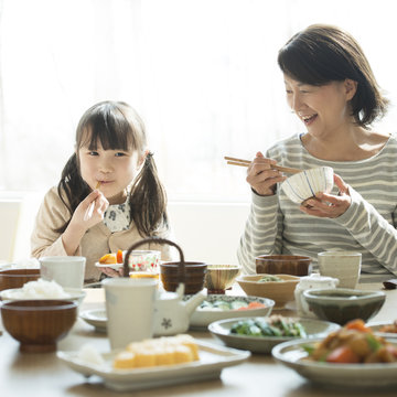 朝食を食べる女の子と祖母