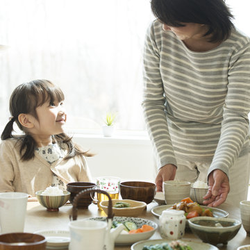朝食を食べる女の子と祖母
