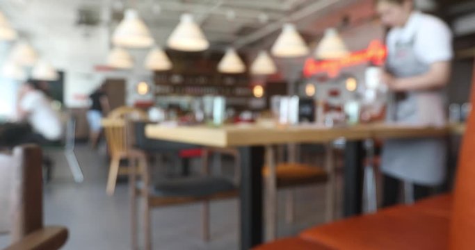 Blurred background of waiter staff and clientsin coffee shop or cafe restaurant with bokeh light