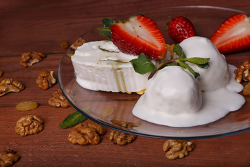 melted ice cream in transparent bowl, decorated with strawberries and biscuit