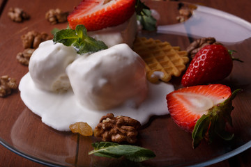 melted ice cream in transparent bowl, decorated with strawberries and biscuit