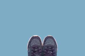 Women's sneakers on a blue background. Minimalism style. Flat lay, top view