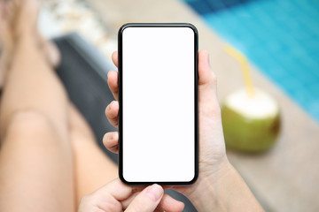 woman by the pool holding phone with isolated screen