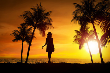 Silhouette of female tourist standing on the beach