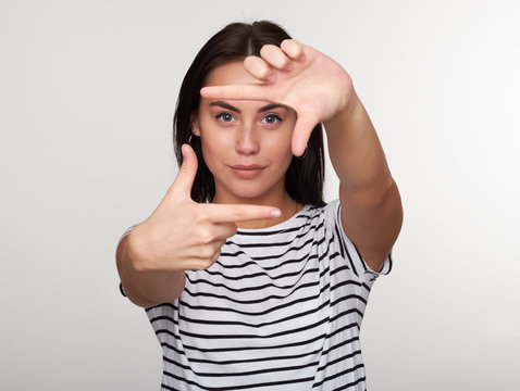 Young woman taking picture with imaginary camera
