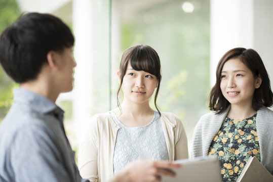 タブレットPCを持ち談笑をする大学生