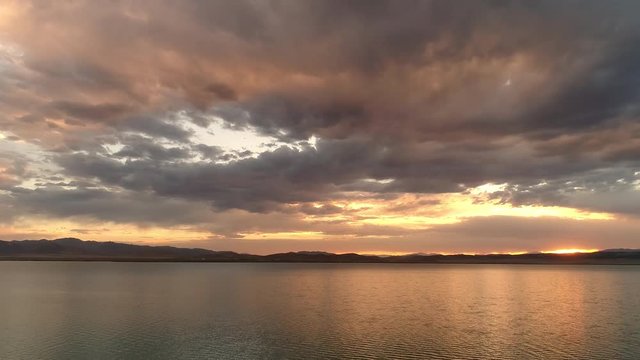 Colorful sunset over Utah Lake with static view from drone.