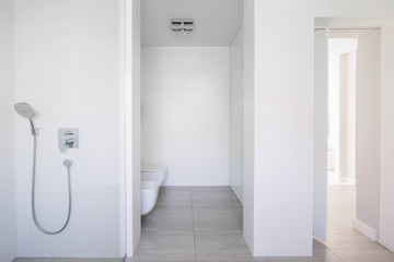 Simple bathroom interior in real photo with glass shower and bla