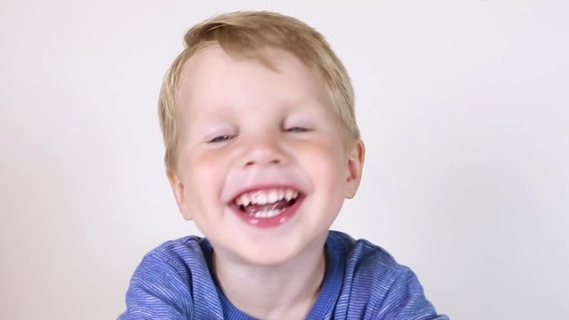 Three years old kid and emotions, close-up portrait of happy smiling kid looking at camera at white background