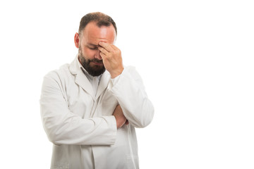 Portrait of male doctor showing migraine gesture