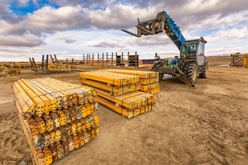 Forklift on a construction site, preparing to raise construction parts
