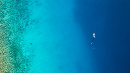 Fototapeta na wymiar Aerial view of young man riding paddleboard