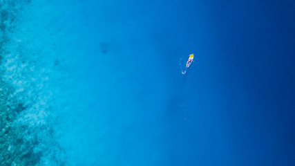 Aerial view of young man riding paddleboard