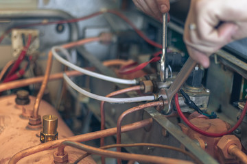 Man master repairs coffee machine with wrenches