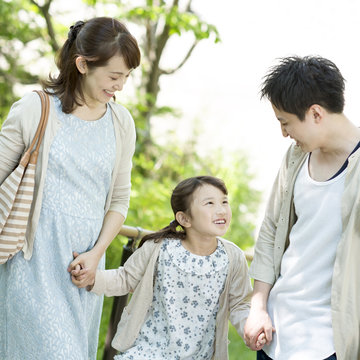 手をつなぎ微笑む家族