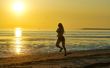 Fototapeta na wymiar girl running by the sea on the beach