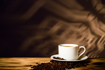 Coffee in a cup on wooden table opposite a defocused  background. Collage. Selective focus