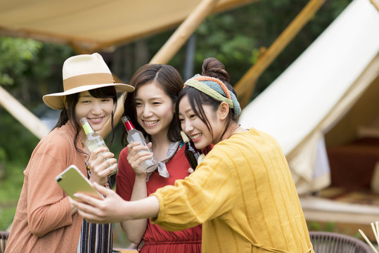 グランピングテントの前で自撮りをする若者たち