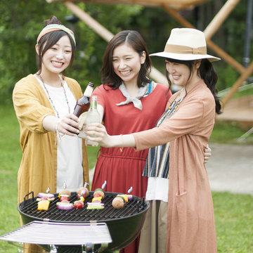 グランピングテントの前で乾杯をする若者たち