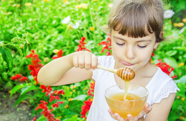 The child eats honey. Selective focus. 
