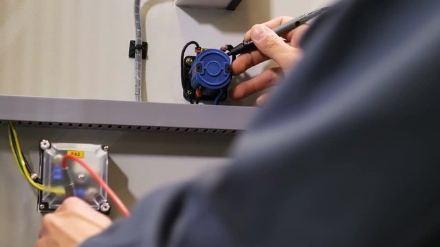 electrician connects to resistors using special tool to measure voltage