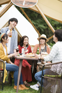 グランピングテントの前で談笑をする若者たち