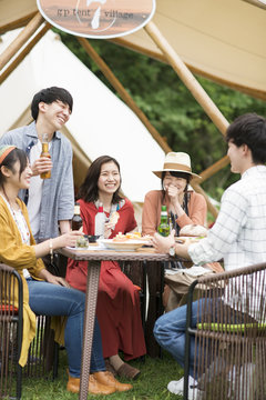 グランピングテントの前で談笑をする若者たち