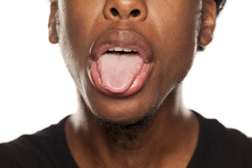 Portrait tongue out closeup of young black african american guy on white background