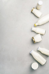 Naklejka premium Various bottles of milk on grey concrete background