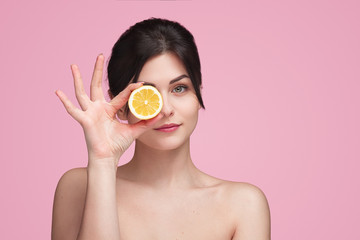 Woman with orange slice in studio