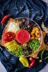 Ajapsandal vegetable stew ingredients on a big glass dish with ajika chilly pepper sauce in the middle. Traditional Georgian caucasus food for lunch or dinner. Vegan vegetarian healthy food