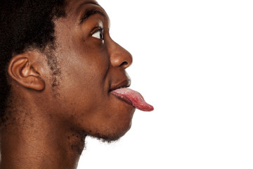 Obraz premium Język profilu się zbliżenie młody czarny facet Afroamerykanin na białym tle