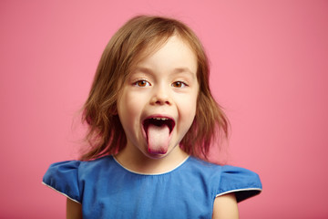 Isolated portrait of kid girl with wide open mouth and protruding tongue.