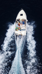 Aerial birds eye view from drone of boat cruising in high speed in turquoise water, island of...