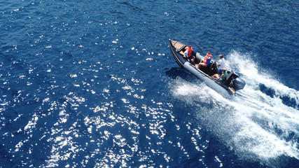 Aerial bird's eye view of inflatable rib boat cruising in high speed in deep blue mediterranean sea