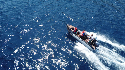 Aerial bird's eye view of inflatable rib boat cruising in high speed in deep blue mediterranean sea