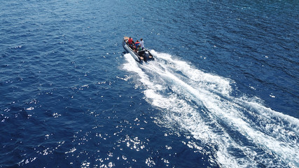 Obraz premium Aerial bird's eye view of inflatable rib boat cruising in high speed in deep blue mediterranean sea