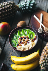 Yogurt with different fruits on a wooden background. Useful food, diet, organic.